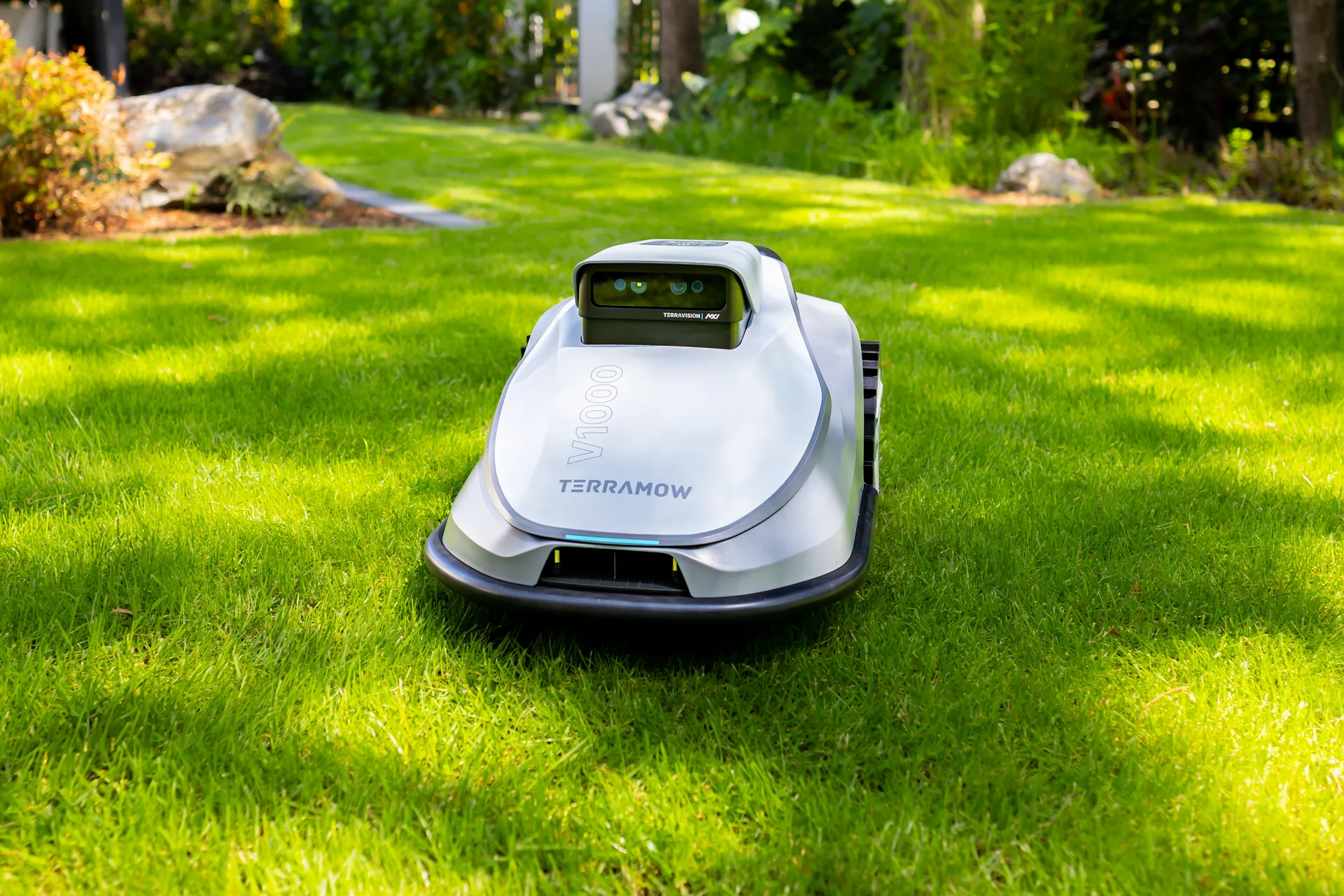 Technik z robotem koszącym w ogrodzie
